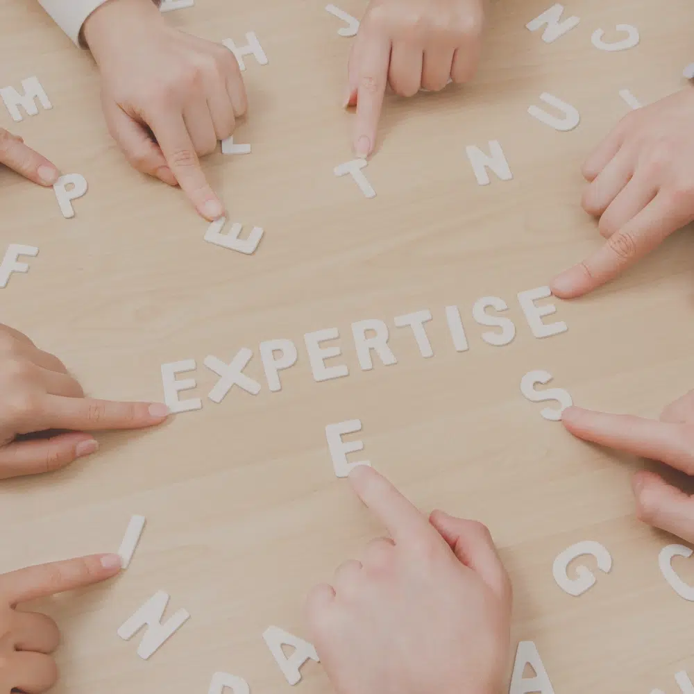 Plusieurs mains montrant le mot expertise pour un accompagnement personnalisé